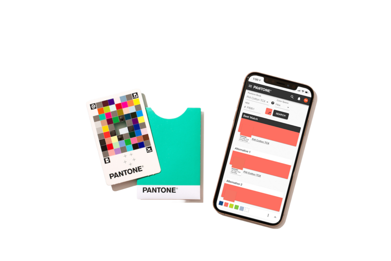 Um cartão Pantone de combinação de cor com seu envelope protetor ao lado do app Pantone Connect aberto no celular